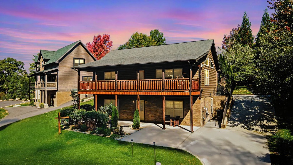 Pigeon Hills cabin exterior at sunset with wraparound deck fall foliage and mountain landscaping