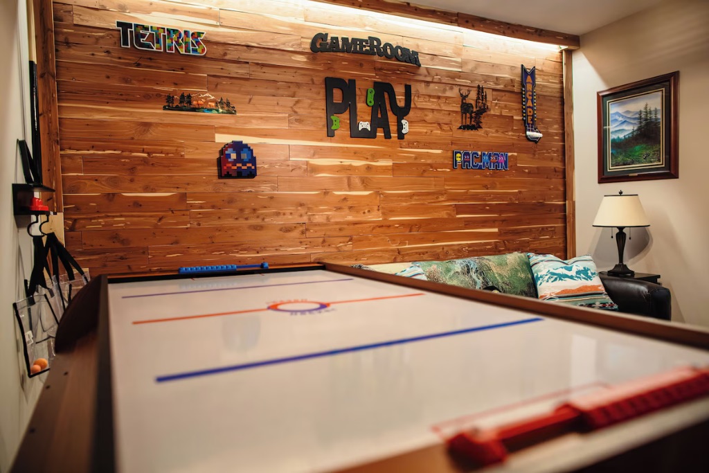 Pigeon Hills game room air hockey table with PLAY sign and gaming couch