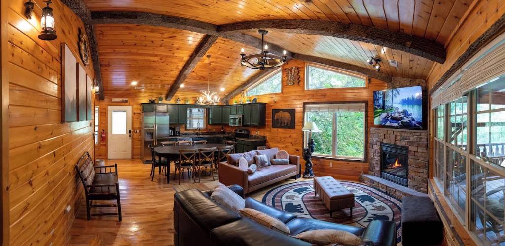 Pigeon Hills open concept living room and kitchen with vaulted ceilings stone fireplace and modern appliances