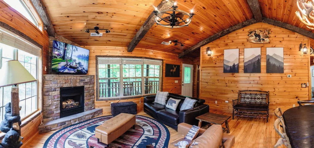 Pigeon Hills living room with stone fireplace vaulted ceilings leather couches and mountain artwork