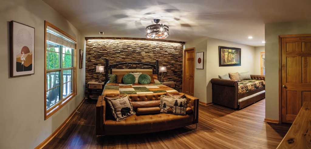 Pigeon Hills master suite panoramic view with king bed seating area wood accent wall and mountain artwork